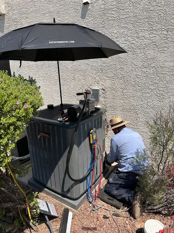 HVAC technician performing outdoor AC maintenance in Desert Palms